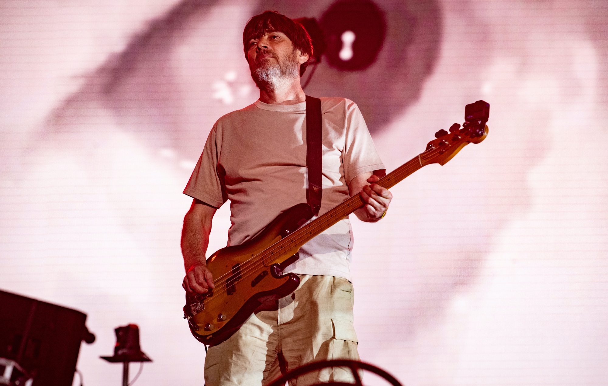 Alex James performing live on stage with Blur, photo by Timothy Norris/Getty