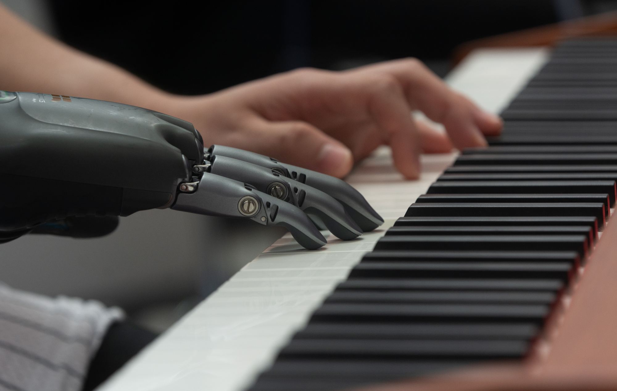 A man demonstrates a prosthetic hand playing the piano at the Shanghai New Expo Center during the World Artificial Intelligence Conference 2025 (Photo by Ying Tang/NurPhoto via Getty Images)