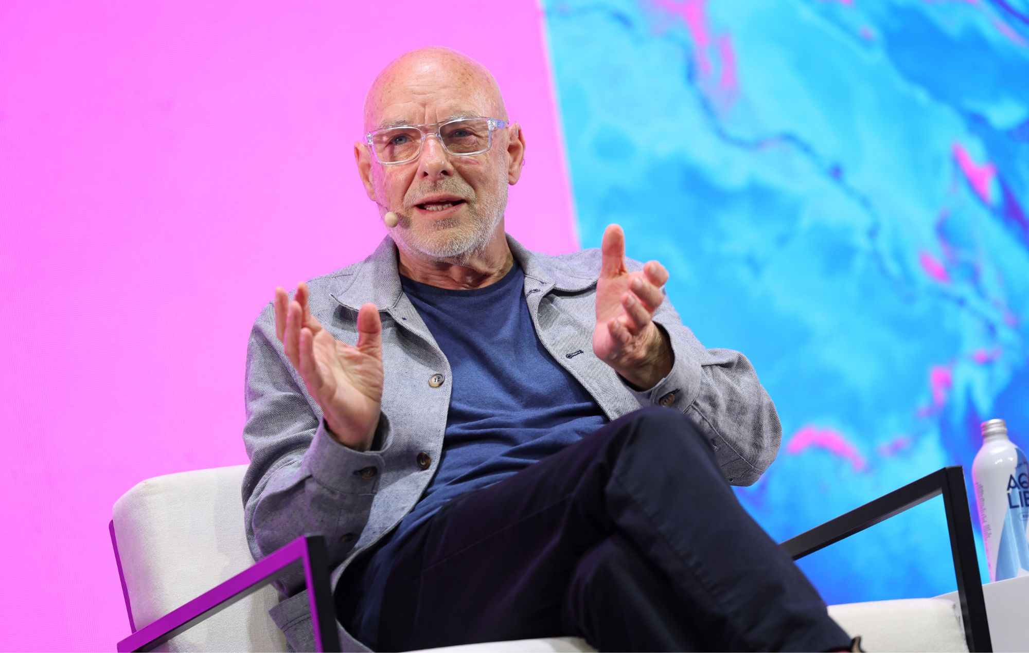 Brian Eno speaks on stage in 2026