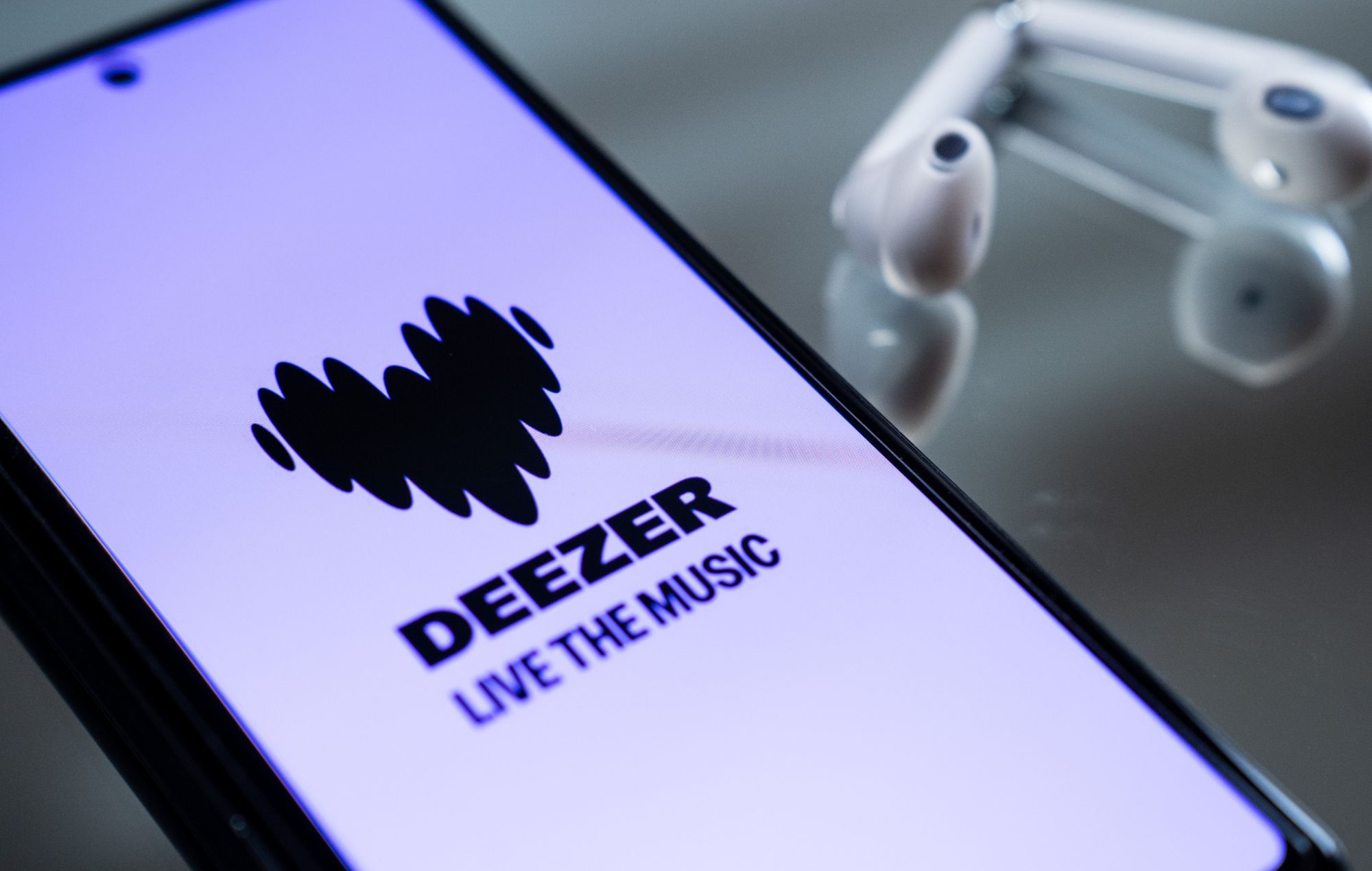Deezer logo is displayed on a smartphone screen