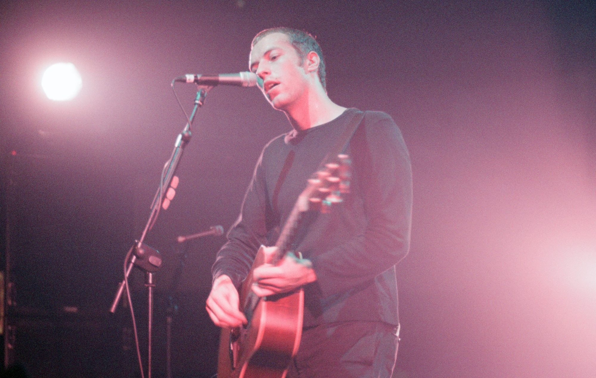 Chris Martin performing live on stage with Coldplay in 2000, photo by Western Mail Archive/Mirrorpix/Getty