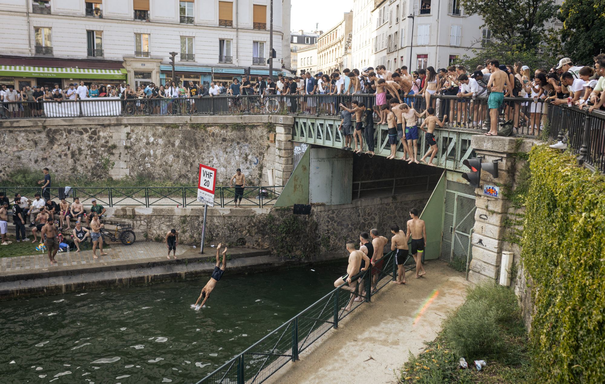Young people swim in the Canal Saint-Martin in Paris, France. The activity takes place during a spell of extreme heat on Fete de la Musique, following the Paris City Council's permission to swim in the canal. (Photo by Telmo Pinto/NurPhoto via Getty Images)