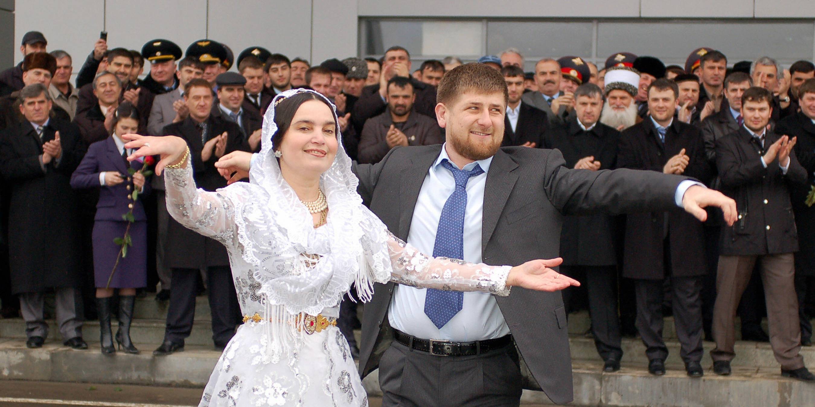 Chechen President Ramsan Kadyrov dances with a woman as they wait for a first flight at the airport in Grozny, 08 March 2007. (Photo credit should read DMITRY NIKOFOROV/AFP via Getty Images)