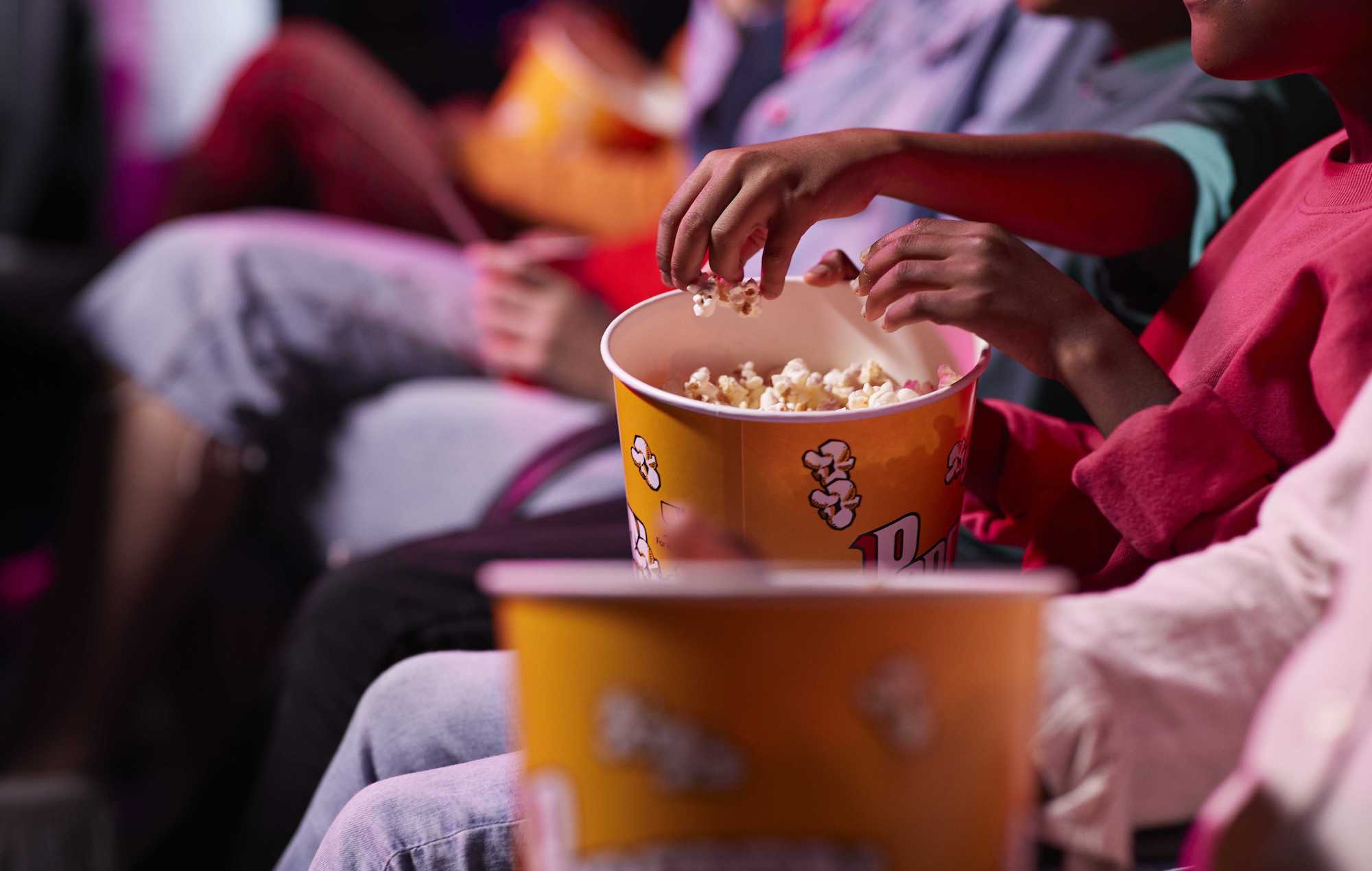 friends sharing popcorn at the movies
