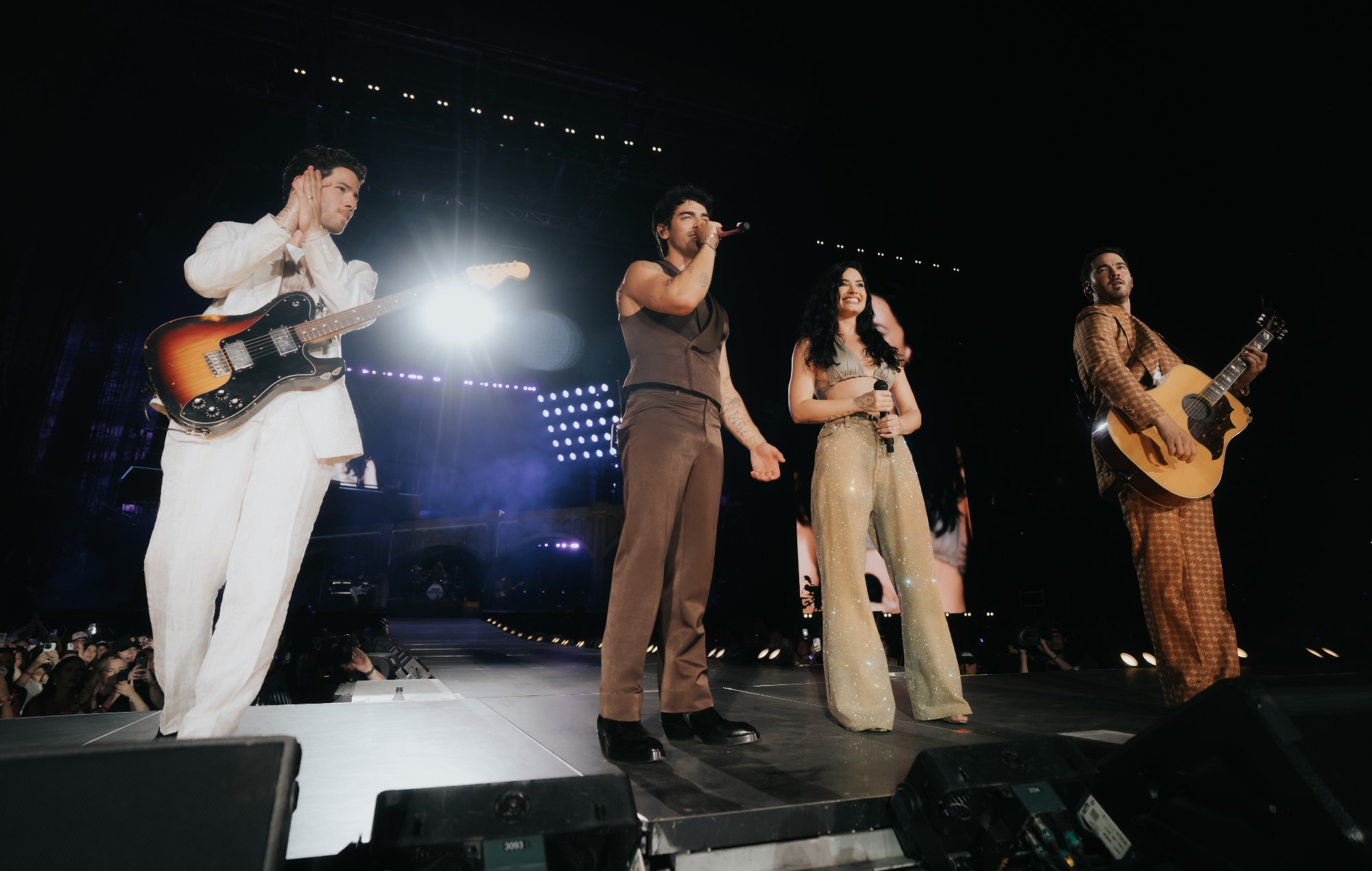 The Jonas Brothers perform live with Demi Lovato.